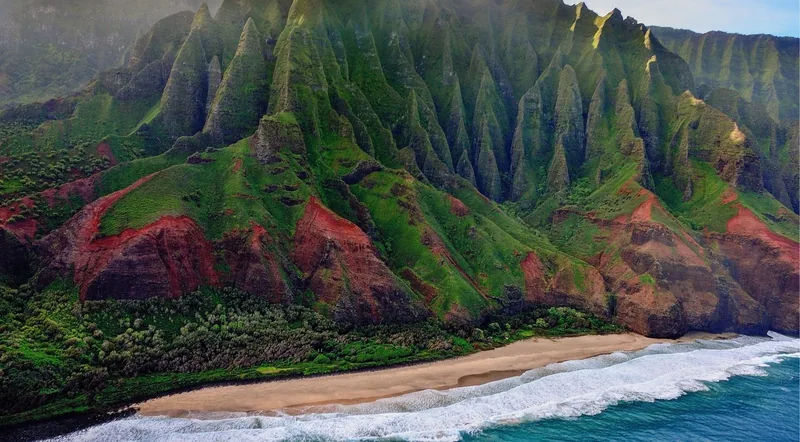The fluted green ridges of Kauai's Nā Pali Coast dropping to a golden beach, seen on a helicopter tour