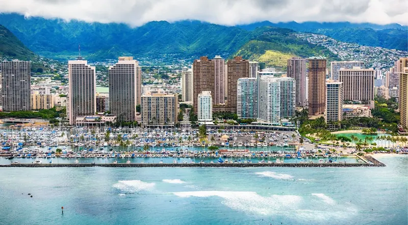 Waikiki's hotel skyline and yacht harbour with the Koʻolau range rising behind, seen from a helicopter
